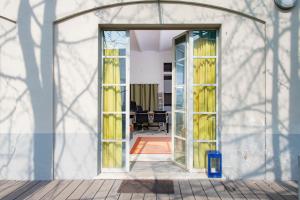 ミラノにあるSTUDIO GINKO - Cozy studio for travel and workの黄色いカーテンの開いたドア