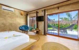 a bedroom with a bed and a large window at Safaya Luxury Villas - Adults only in Nungwi