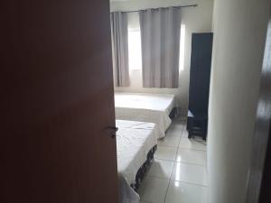 a room with two beds and a window at CASA em CALDAS NOVAS in Caldas Novas