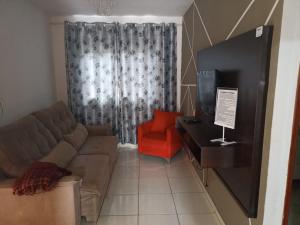 a living room with a couch and a tv at CASA em CALDAS NOVAS in Caldas Novas