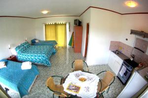 una camera d'albergo con due letti e un tavolo con sedie di Honu Nui a Hanga Roa