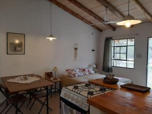 cocina y sala de estar con fogones y cama en PIQUILLIN CASA PARA DOS en Las Rabonas