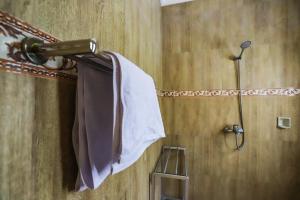 a bathroom with a shower with a towel on a rack at Big Stone House 7 - 6 min Center and 500m Parq Ubud in Ubud
