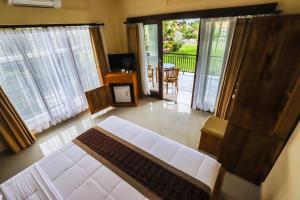 a living room with a white couch and sliding glass doors at Big Stone House 7 - 6 min Center and 500m Parq Ubud in Ubud