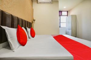 a bedroom with a bed with red pillows at Super OYO Hotel Sky Orchid in Ludhiana