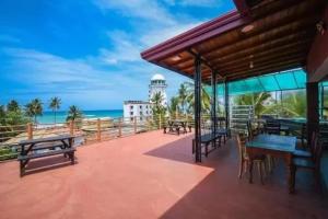 een patio met tafels en banken op het strand bij Ran Dhara Beach Resort in Ambalangoda
