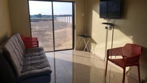 salon z kanapą, krzesłem i telewizorem w obiekcie Airport Airbnb family units w mieście Richards Bay
