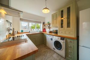 a kitchen with a washer and dryer at Meadow View - Cosy townhouse with patio garden & parking in Kendal