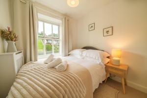 a bedroom with a bed with towels on it at Meadow View - Cosy townhouse with patio garden & parking in Kendal