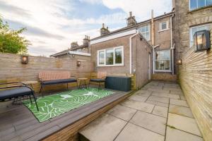 a patio with two chairs and a table at Meadow View - Cosy townhouse with patio garden & parking in Kendal