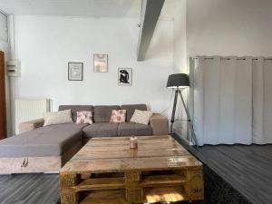 a living room with a couch and a coffee table at L'appartement Marceau - 55m2 - Carcassonne centre in Carcassonne