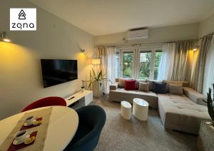 a living room with a couch and a tv at Zona Apartments 3 in Zrenjanin