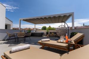eine Terrasse mit Tischen und Stühlen auf dem Dach in der Unterkunft Costa Deluxe in Funtana