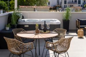 einen Tisch und Stühle auf einer Terrasse mit Whirlpool in der Unterkunft Costa Deluxe in Funtana