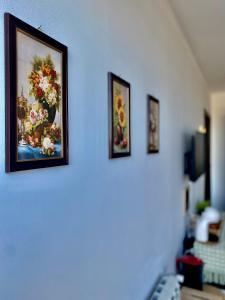uma parede com três fotografias de flores em 4 Room Rental Unit em Marginea