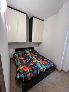 a bedroom with a bed with a colorful quilt on it at Gran Baita Residence in Passo del Tonale