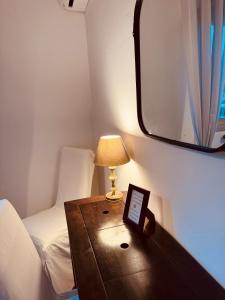 ジュアン・レ・パンにあるAppartement "Laura" Terrasse - Parking - Plageのベッド1台、テーブル(ランプ付)が備わる小さな客室です。