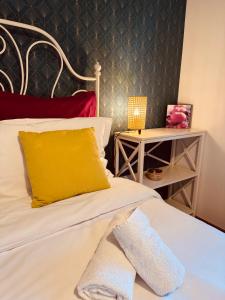 a bed with a yellow pillow and a side table at Appartement "Laura" Terrasse - Parking - Plage in Juan-les-Pins