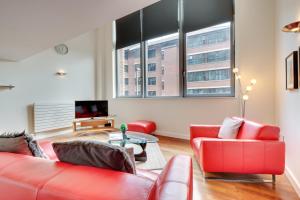 a living room with two red couches and a tv at Crown Apartments 104 by Week2Week in Newcastle upon Tyne