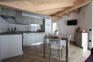 a kitchen and dining room with a table and chairs at Appartamenti ai Stabli 2 in Mezzana