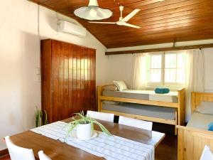 a room with a table and two bunk beds at Cabañas Los 5 Sauces in Santa Clara del Mar