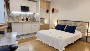 - une chambre avec un grand lit et des oreillers bleus dans l'établissement Le studio d'Agathe centre historique - Confort & Calme, à Valence
