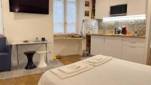 a kitchen with a bed and a table in a room at Le studio d'Agathe centre historique - Calme & Confort in Valence