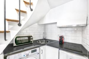 a kitchen with a sink and a washing machine at Grands Boulevards - Vivienne 1bdr in Paris