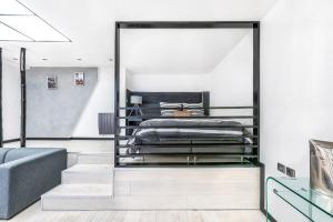 een slaapkamer met een bed en een bank bij Notre Dame des Champs - Vavin 1bdr in Parijs