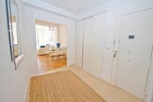 a hallway with white walls and a door with a rug at Promenade des Anglais - Sea View 2bdr in Nice