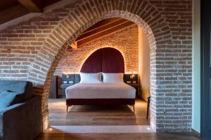 a bedroom with a bed in a brick wall at Pavillon Suite in Peschiera del Garda