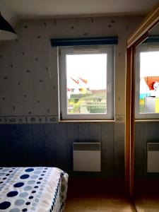 1 dormitorio con 2 ventanas y 1 cama. en Bleu-De-Toi, en Wimereux