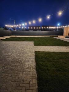 a courtyard with lights on a building at night at Nisa Kub Residence in Hărman