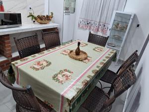 a table with a table cloth with a bottle on it at GUI e LU ACOMODAÇOES in Penha