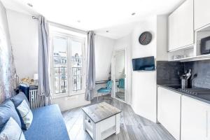 eine Küche mit einem Sofa und einem Tisch in einem Zimmer in der Unterkunft Champs Elysees - Mac Mahon Studio in Paris