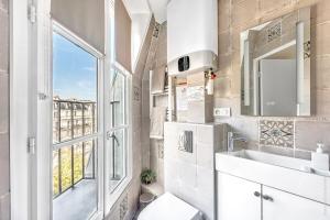 uma casa de banho com um WC, um lavatório e uma janela em Champs Elysees - Mac Mahon Studio em Paris