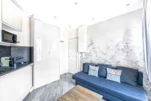 ein Wohnzimmer mit einer blauen Couch in einer Küche in der Unterkunft Champs Elysees - Mac Mahon Studio in Paris
