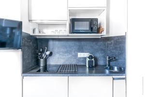 a kitchen with a sink and a microwave at Studio Mac Mahon - Champs Elysees in Paris