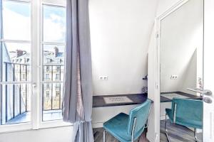 a room with a window and two chairs and a table at Studio Mac Mahon - Champs Elysees in Paris