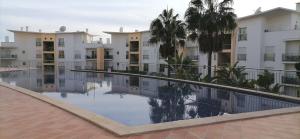 an empty swimming pool in front of a building at Encosta Da Orada in Albufeira