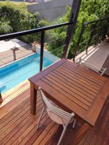 un banco de madera sentado en una terraza junto a una piscina en SLB Apart - Duplex en San Luis
