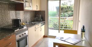 アルブフェイラにあるEncosta Da Oradaのキッチン(シンク、コンロ付)、窓が備わります。