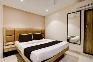 ムンバイにあるHotel Al Ibrahimのベッドルーム(大型ベッド1台、鏡付)