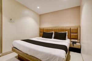 a bedroom with a large bed with a wooden headboard at Hotel Al Ibrahim in Mumbai