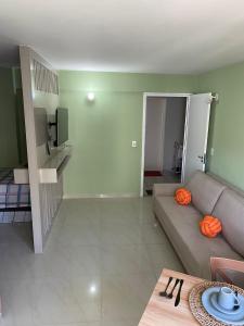 uma sala de estar com um sofá e uma televisão em Quarto e Sala Beira Mar Maceió em Maceió