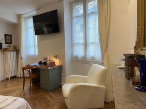 a bedroom with a desk and a chair and a tv at Chambre de charme au coeur du vieux Valence - Confort & Calme in Valence