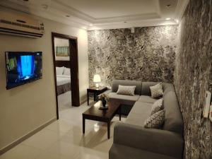 a living room with a couch and a tv at العالية للشقق المفروشه الشهري in Jeddah
