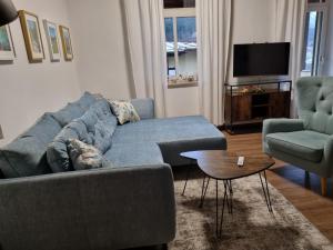 ベルヒテスガーデンにあるVilla Maxのリビングルーム(青いソファ、椅子2脚付)