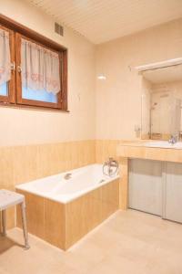 y baño con bañera y lavamanos. en Chalet des 3 Vallées, spacious and comfortable 12p, en La Bresse