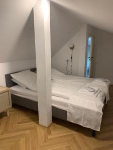 a bedroom with a white bed with a wall at Kaunas Embassy Apartments in Kaunas